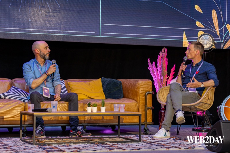 Deux intervenants assis sur un canapé en cuir sur scène, décor coloré et scénographie soignée pendant le Festival numérique Web2Day à Nantes