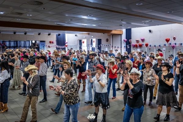 Danseurs en lignes applaudissant dans la salle décorée de ballons cœur