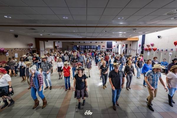 Vue élevée de la salle avec couples dansant, guirlandes et ballons cœur