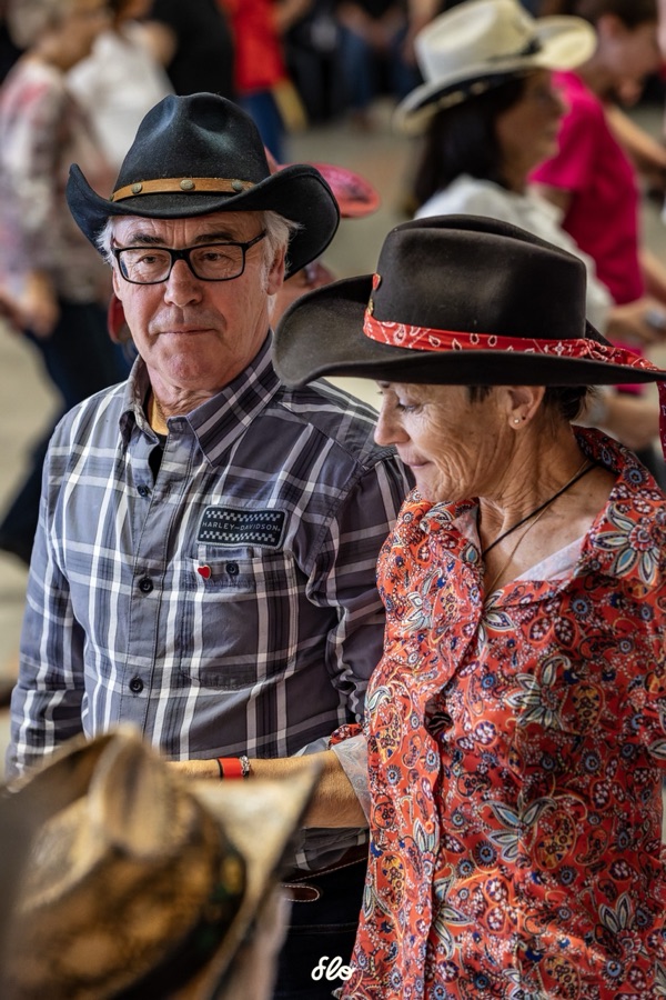 Couple de danseurs en chapeaux noirs échangeant un regard entre deux danses