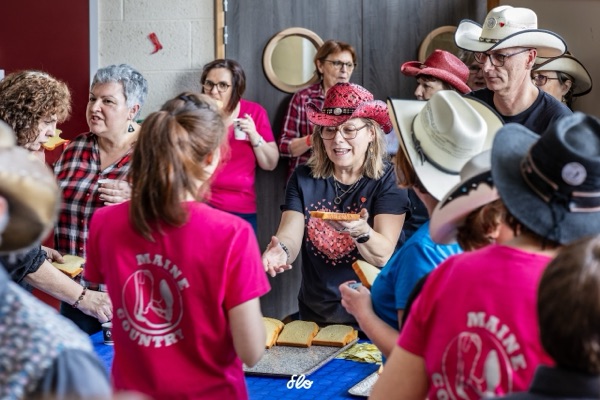 Bénévoles en t-shirts roses Maine Country distribuant des galettes aux participants