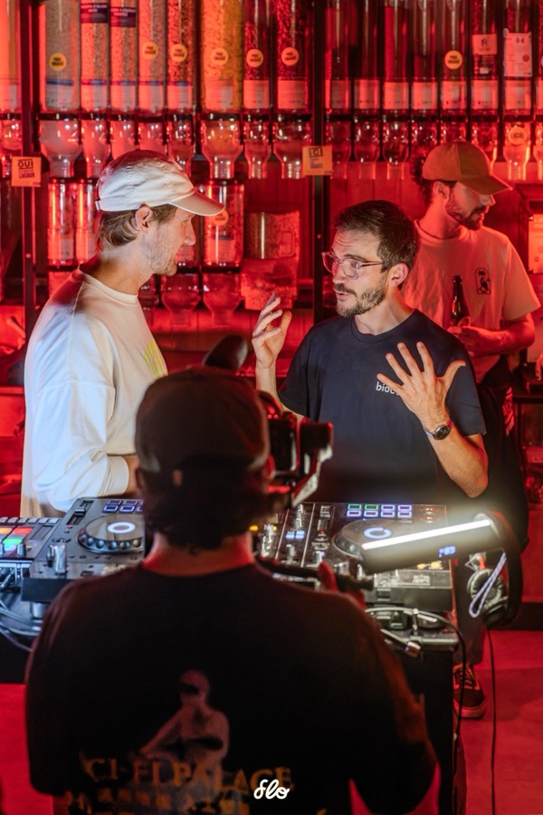 Deux personnes discutant derrière les platines, caméraman au premier plan